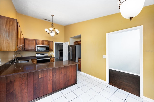 kitchen with light wood-type flooring, decorative light fixtures, appliances with stainless steel finishes, a notable chandelier, and sink