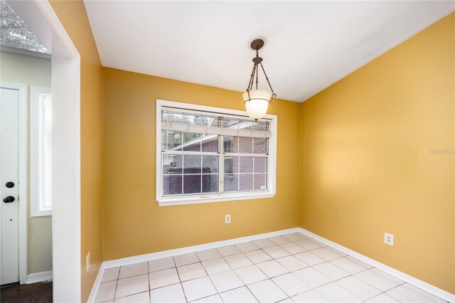 empty room featuring a healthy amount of sunlight and tile patterned floors