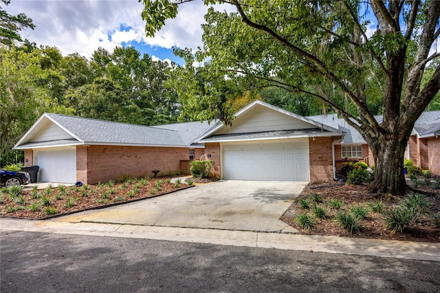 ranch-style home with a garage, brick siding, and driveway