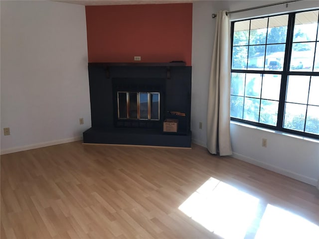 unfurnished living room featuring light hardwood / wood-style flooring and plenty of natural light