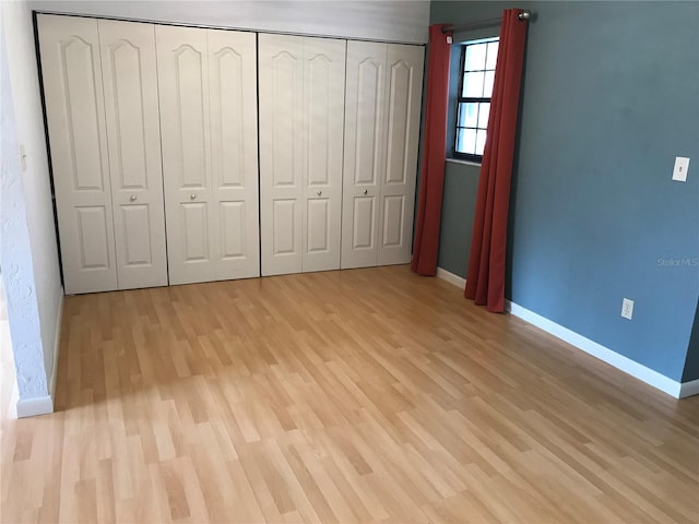 unfurnished bedroom featuring a closet and light wood-type flooring