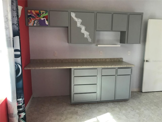 kitchen with built in desk and gray cabinetry