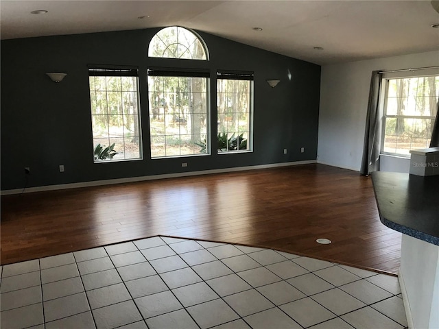 empty room with lofted ceiling and hardwood / wood-style floors