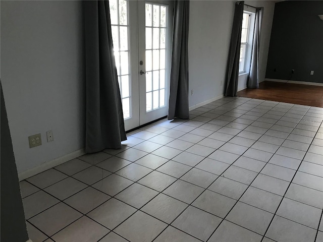 tiled empty room featuring french doors