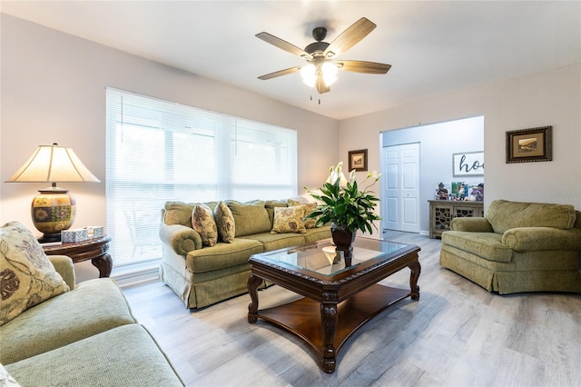 living area with light wood finished floors and a ceiling fan