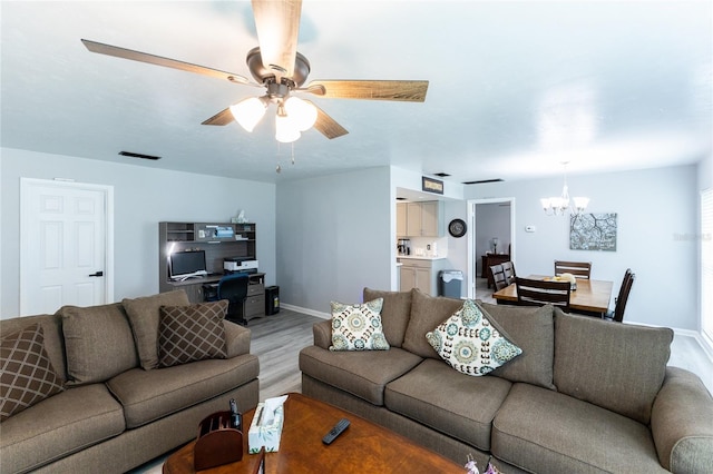 living room featuring baseboards, visible vents, light wood finished floors, and ceiling fan with notable chandelier