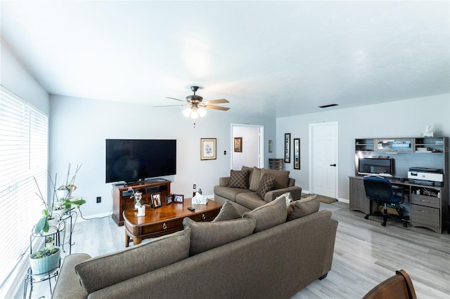 living area featuring light wood-style floors, visible vents, baseboards, and a ceiling fan