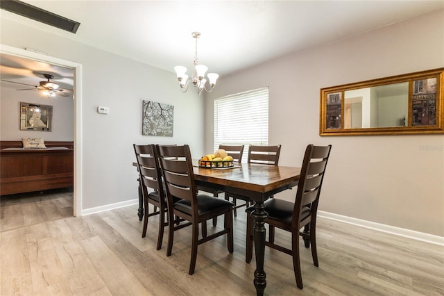 dining area with light wood-style floors, baseboards, and ceiling fan with notable chandelier