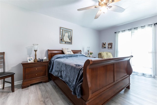 bedroom with a ceiling fan, baseboards, and light wood finished floors