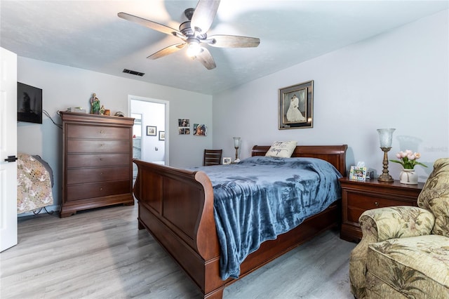 bedroom featuring light wood-type flooring, visible vents, and a ceiling fan