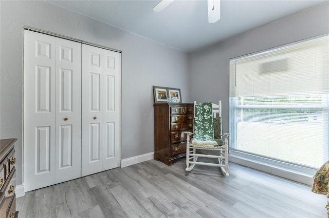 sitting room featuring ceiling fan, light wood-style flooring, and baseboards