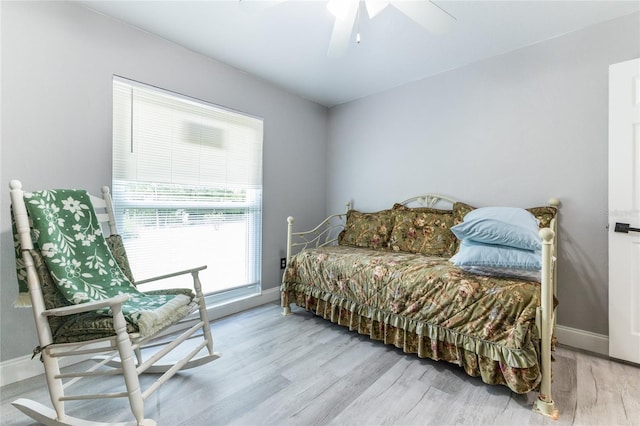 bedroom with baseboards, a ceiling fan, and light wood-style floors