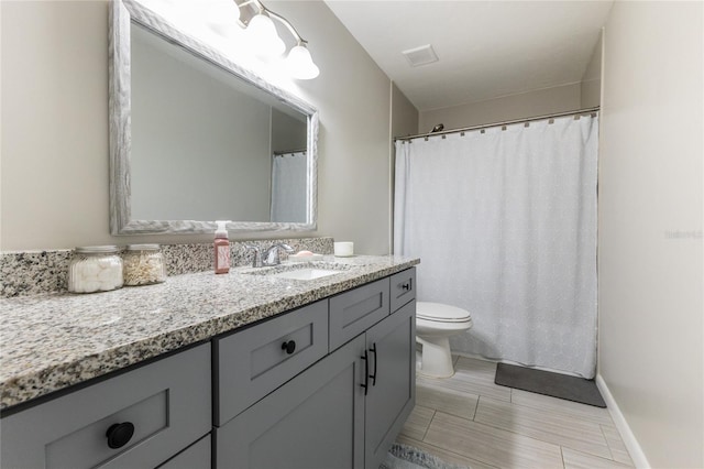 bathroom with visible vents, baseboards, vanity, and toilet