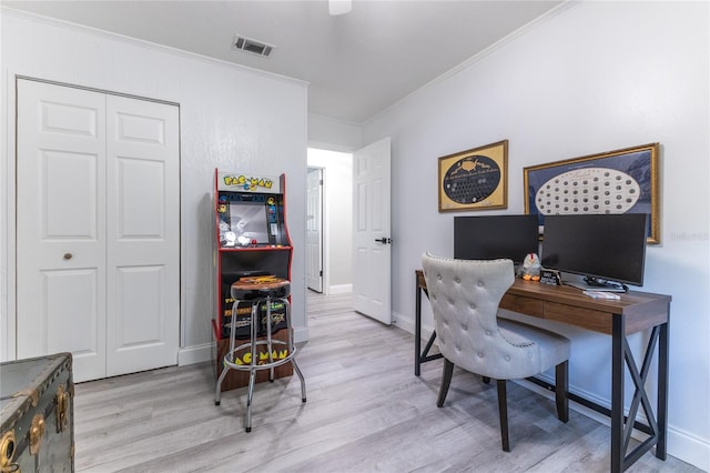 office space with ornamental molding, visible vents, light wood-style flooring, and baseboards