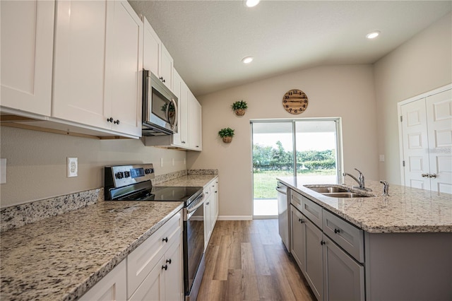 kitchen with appliances with stainless steel finishes, a sink, and white cabinets