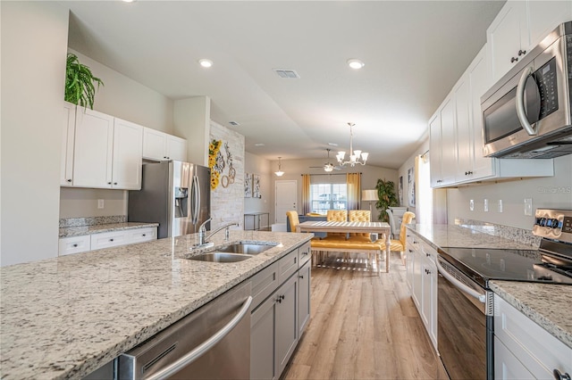 kitchen featuring stainless steel appliances, white cabinetry, and a sink