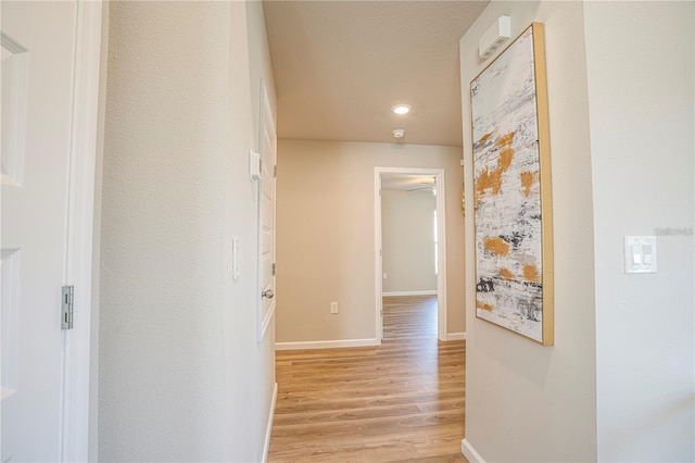 hall featuring light wood-type flooring and baseboards