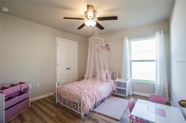 bedroom with ceiling fan, a closet, baseboards, and dark wood-style flooring