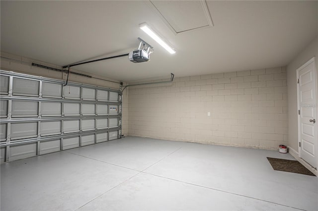 garage featuring a garage door opener and concrete block wall