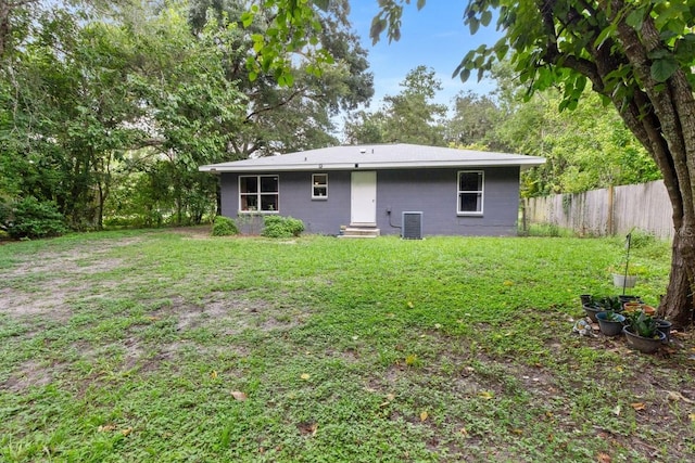 back of house featuring a yard and central AC