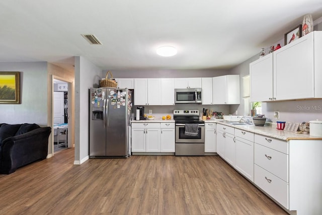 kitchen featuring sink, hardwood / wood-style floors, stainless steel appliances, and white cabinets