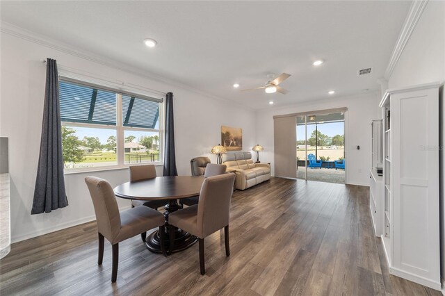 dining room with ceiling fan, dark hardwood / wood-style floors, plenty of natural light, and crown molding