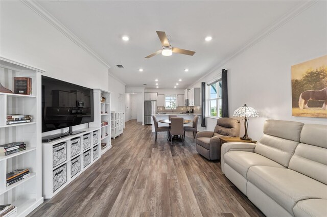 living room featuring crown molding, hardwood / wood-style floors, and ceiling fan