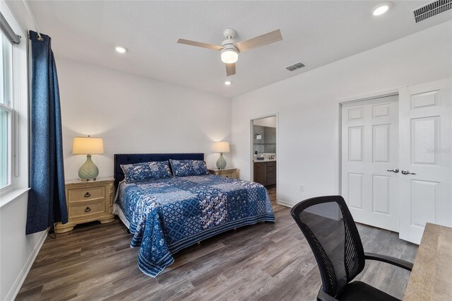 bedroom featuring ceiling fan, ensuite bath, dark wood-type flooring, and multiple windows