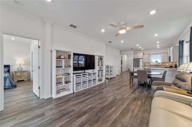 living room featuring ornamental molding, ceiling fan, and light hardwood / wood-style flooring