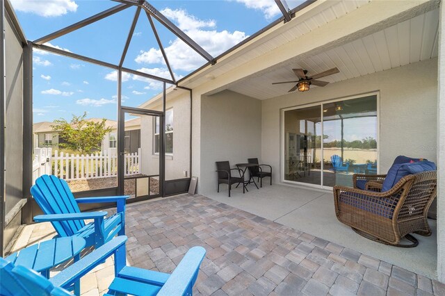 sunroom / solarium featuring beam ceiling and ceiling fan