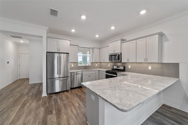 kitchen with white cabinets, kitchen peninsula, stainless steel appliances, dark hardwood / wood-style floors, and sink