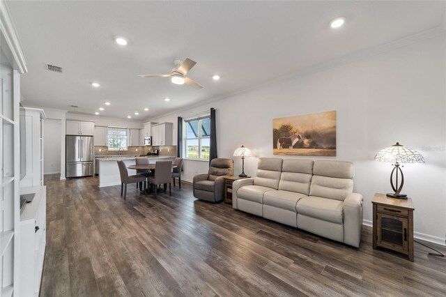 living room featuring ornamental molding, ceiling fan, and dark hardwood / wood-style floors