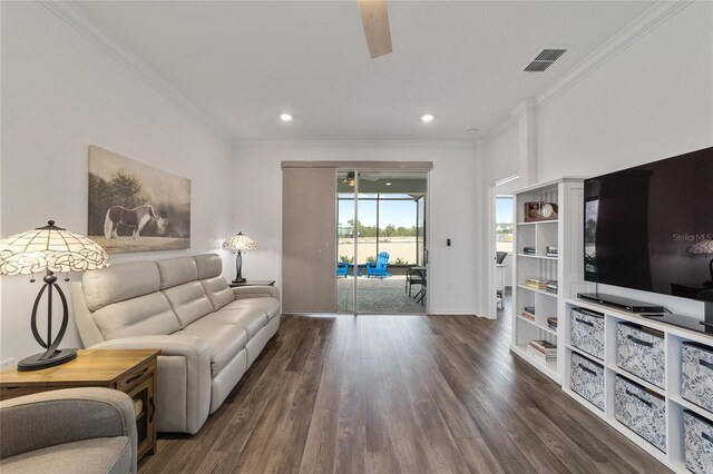 living room featuring ornamental molding, ceiling fan, and dark wood-type flooring