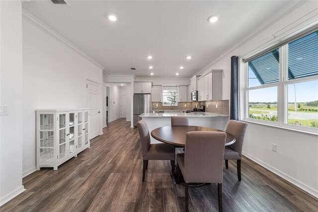 dining area featuring dark hardwood / wood-style floors and ornamental molding