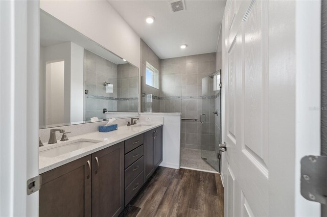 bathroom featuring wood-type flooring, vanity, and an enclosed shower