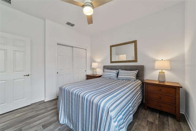 bedroom featuring ceiling fan, dark wood-type flooring, and a closet