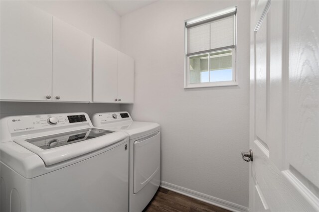 laundry area featuring separate washer and dryer, cabinets, and dark wood-type flooring