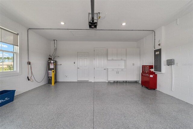 garage with a garage door opener, gas water heater, and electric panel