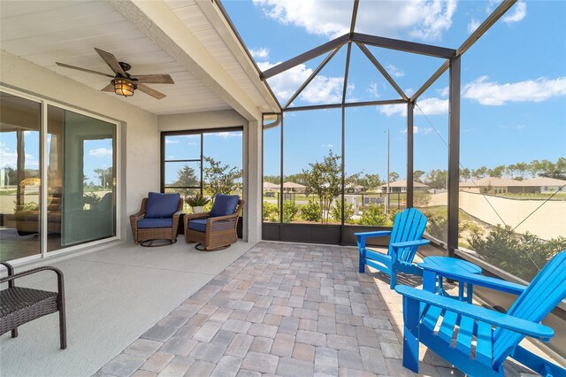 sunroom / solarium featuring beam ceiling and ceiling fan