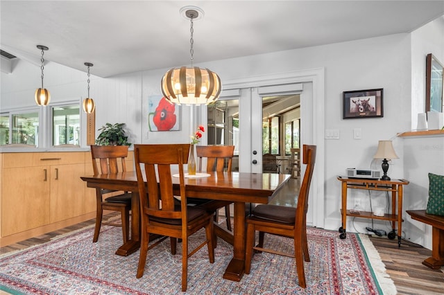 dining room featuring hardwood / wood-style flooring, a notable chandelier, and french doors