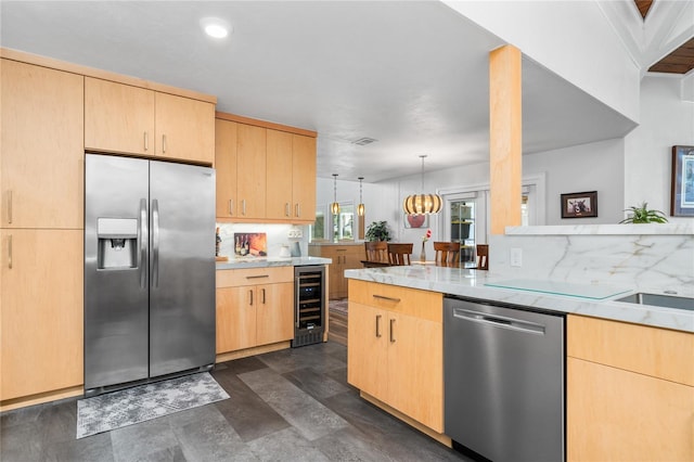 kitchen with backsplash, light brown cabinetry, decorative light fixtures, appliances with stainless steel finishes, and beverage cooler