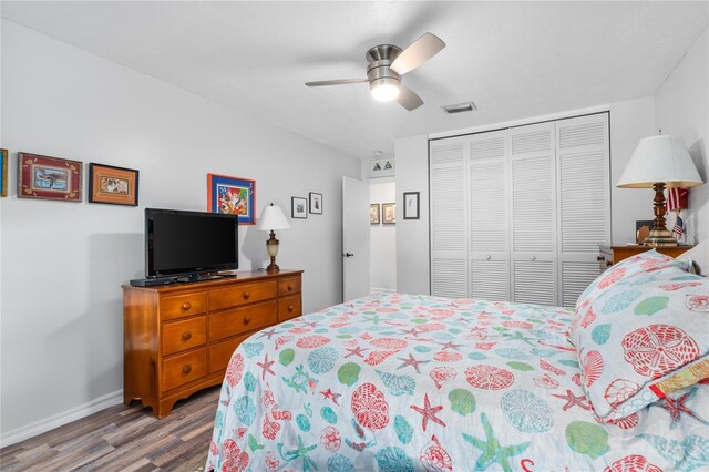 bedroom with hardwood / wood-style flooring, ceiling fan, and a closet