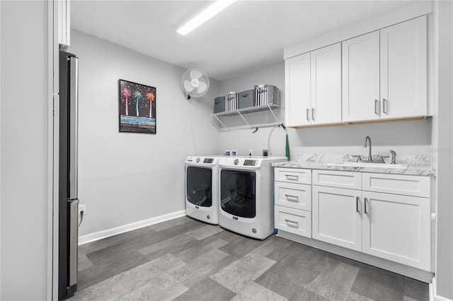 laundry area with independent washer and dryer, sink, and light hardwood / wood-style floors