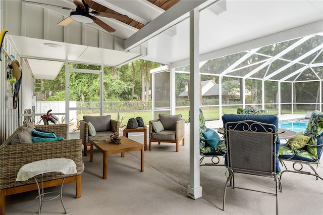 sunroom featuring lofted ceiling with beams and ceiling fan