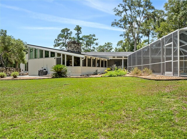 rear view of house featuring a yard, a lanai, and a patio area