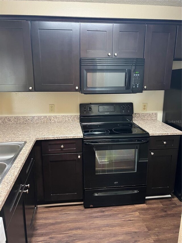 kitchen with black appliances, dark hardwood / wood-style floors, and sink