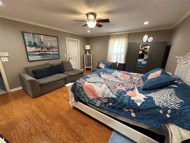 bedroom with crown molding, hardwood / wood-style flooring, and ceiling fan