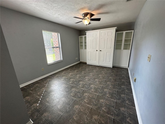 unfurnished bedroom featuring a textured ceiling, a closet, and ceiling fan