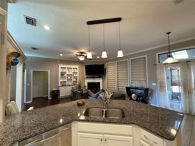 kitchen with white cabinets, hanging light fixtures, sink, and dark hardwood / wood-style flooring