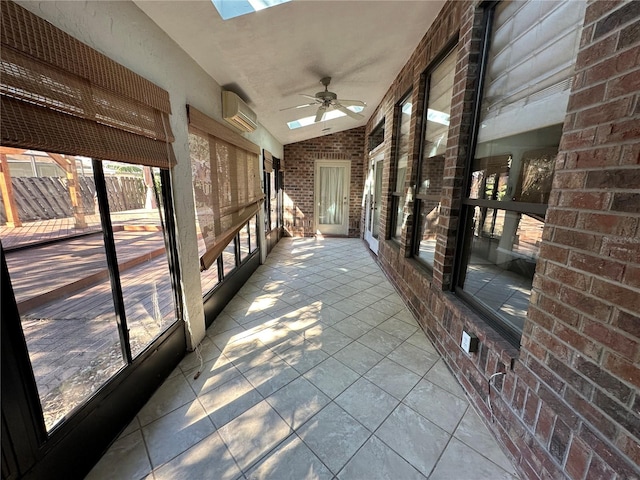 unfurnished sunroom with ceiling fan, a wall mounted AC, and lofted ceiling with skylight